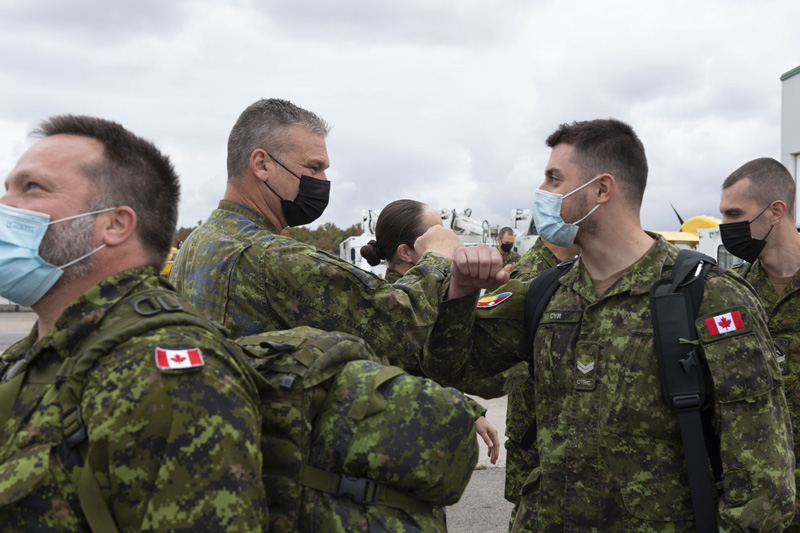 Adjudant-chef Justin Morneau, Sergent-major du 5e Groupe Brigade Mécanisé du Canada (5 GBMC) et le Colonel Marie-Christine Harvey, commandante du 5 GBMC discutent avec les militaires avant leur départ pour l’Ukraine le 29 septembre 2021. 